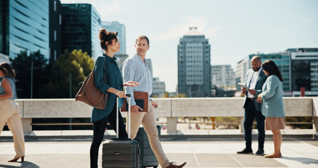 Businesspeople walking with suitcases and talking.